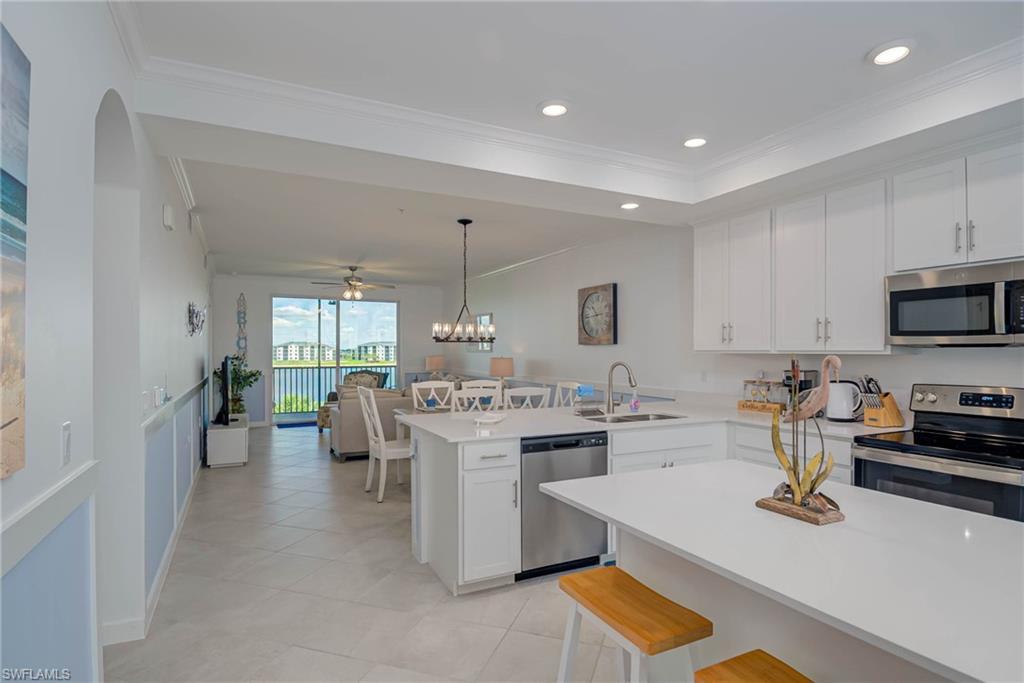 5807 Double Eagle Cir Avenue, Unit 4635 Immokalee, FL 34142 - Photo 4 of 43 a kitchen with a sink a stove and chairs