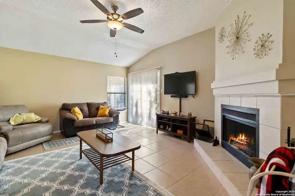 a living room with furniture a flat screen tv and a fireplace