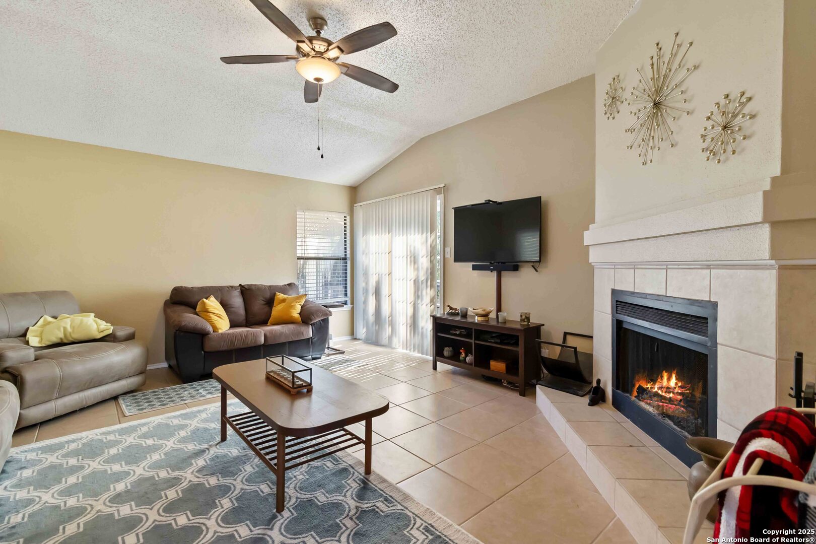 a living room with furniture a flat screen tv and a fireplace