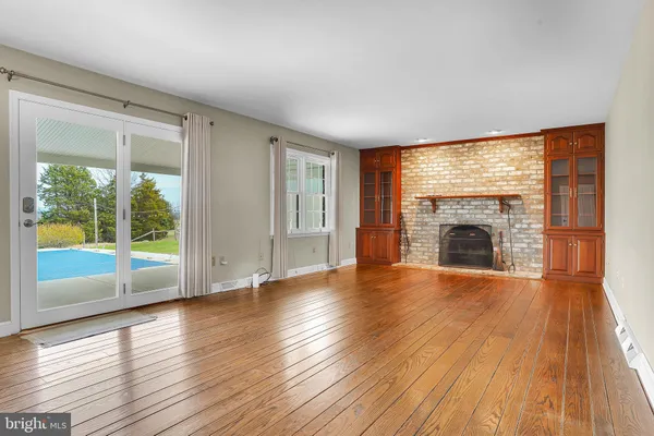 a view of empty room with wooden floor and fireplace