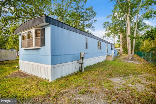 a view of backyard of house with wooden fence