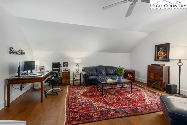 a living room with furniture a rug and a flat screen tv