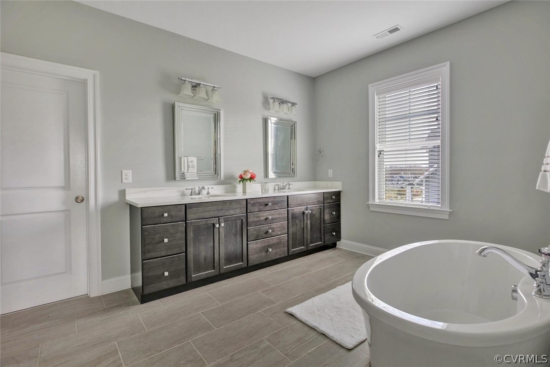 5154 Lake Summer Loop Moseley, VA 23120 - Photo 30 of 41 a spacious bathroom with a double vanity sink a mirror and a bathtub