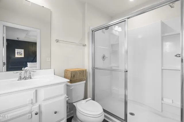 a bathroom with a sink toilet vanity and shower