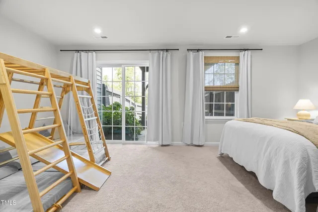a spacious bedroom with a bed and glass door