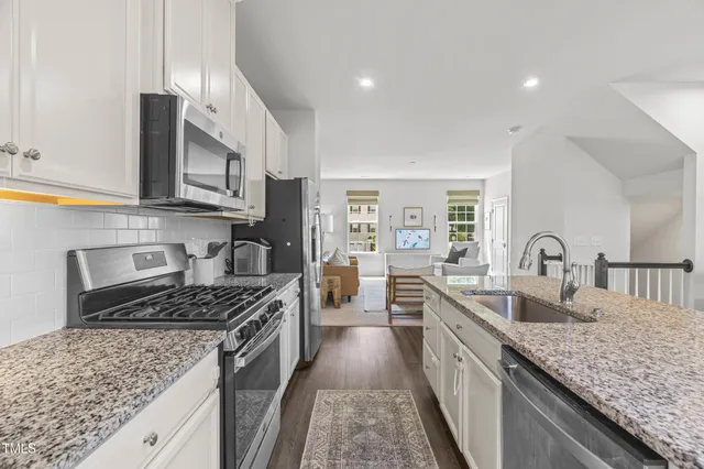a kitchen with stainless steel appliances granite countertop a sink stove and cabinets