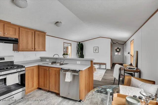 a kitchen with stainless steel appliances granite countertop a stove top oven a sink dishwasher and cabinets with wooden floor