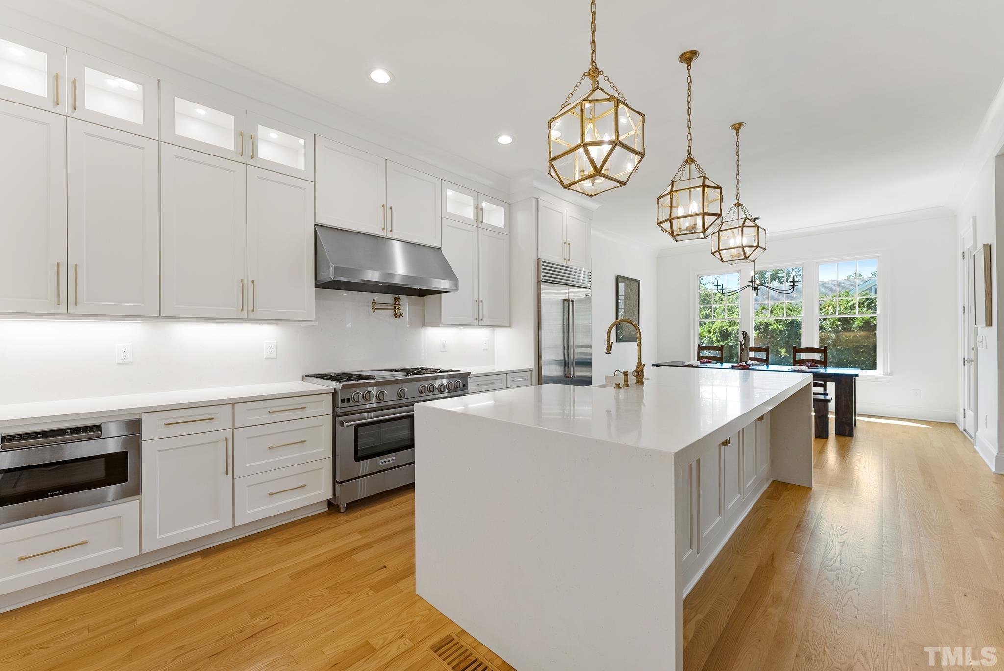 3401 Lewis Farm Road Raleigh, NC 27607 - Photo 17 of 75 a large kitchen with stainless steel appliances granite countertop a sink a stove and a wooden floors