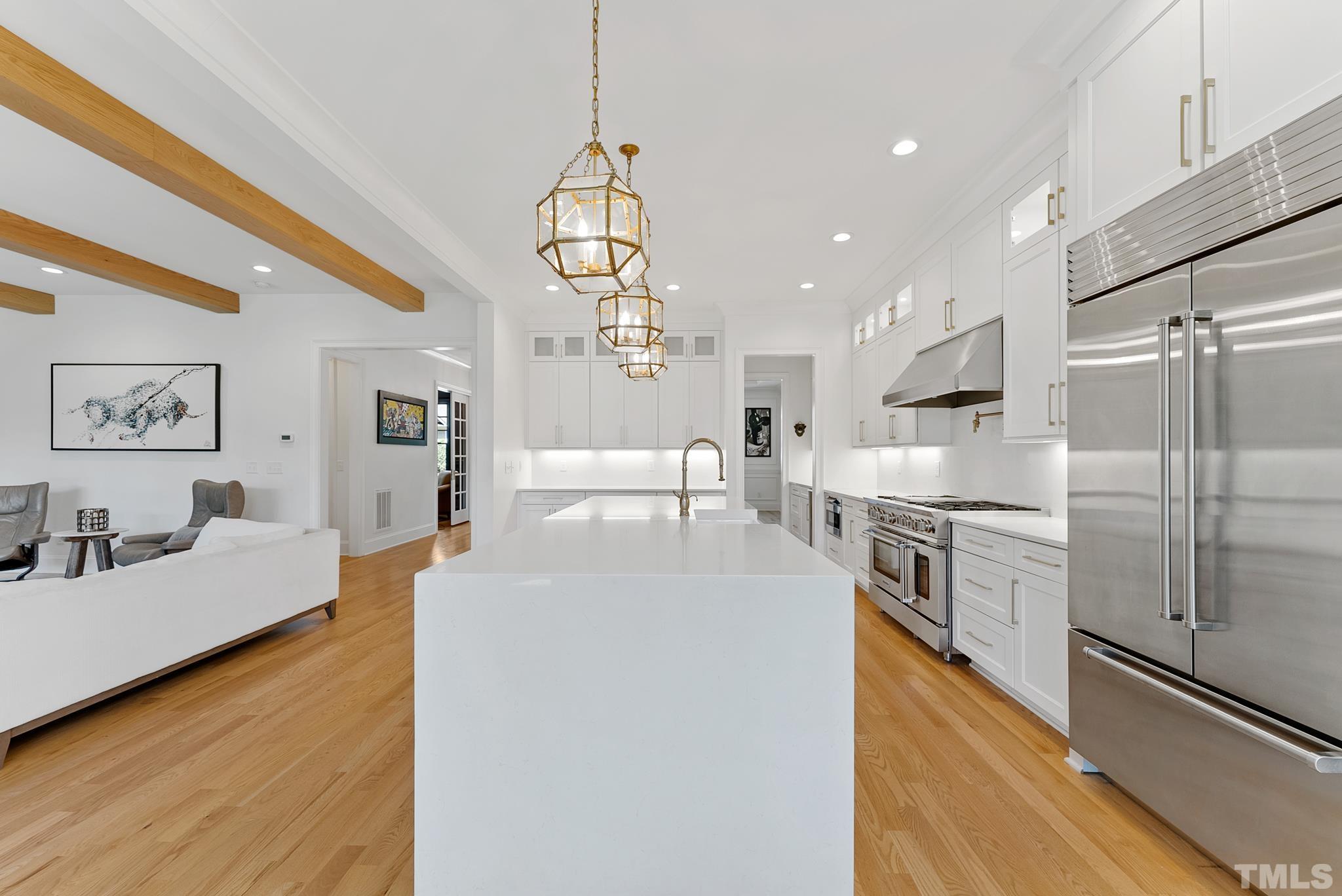 3401 Lewis Farm Road Raleigh, NC 27607 - Photo 18 of 75 a large kitchen with stainless steel appliances kitchen island a stove a refrigerator a oven and a sink with couches