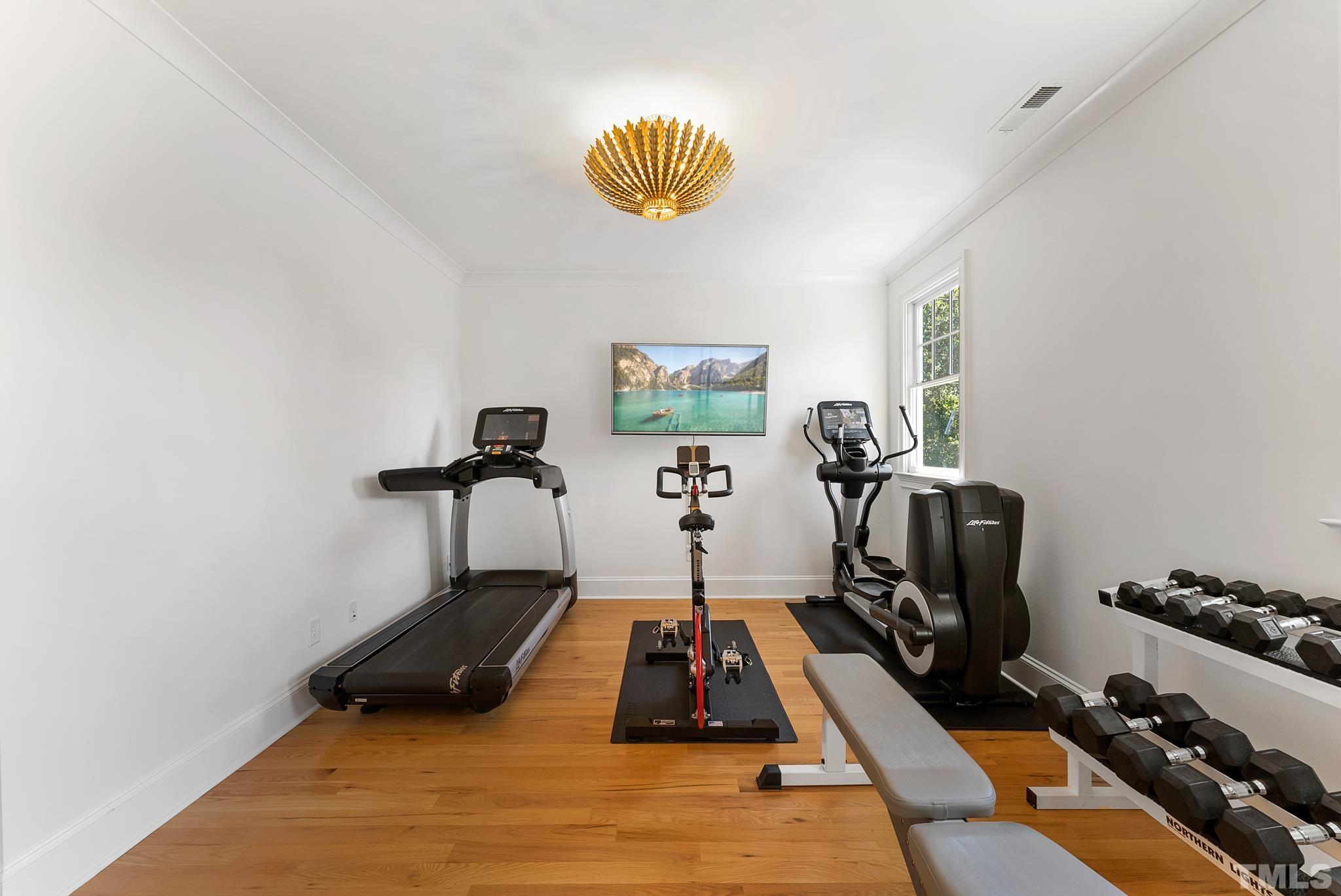 3401 Lewis Farm Road Raleigh, NC 27607 - Photo 37 of 75 a room with gym equipment and wooden floor
