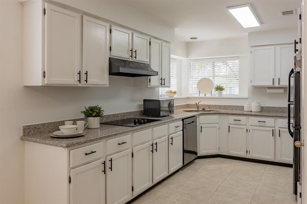 19406 Enchantington Circle features an inviting kitchen with pretty granite countertops, fresh white paint and decorative hardware.