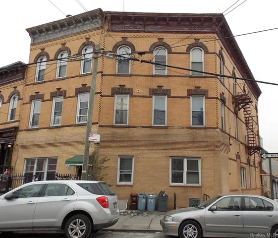 a front view of a residential apartment building with a car parked