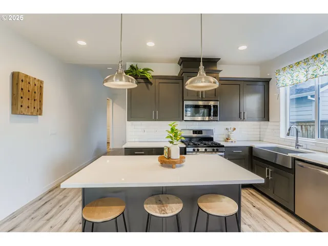 a kitchen with a dining table chairs and white cabinets