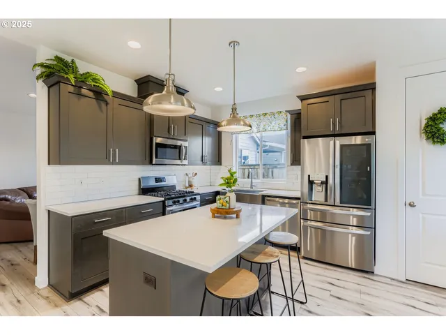 a kitchen with a sink stainless steel appliances and chandelier