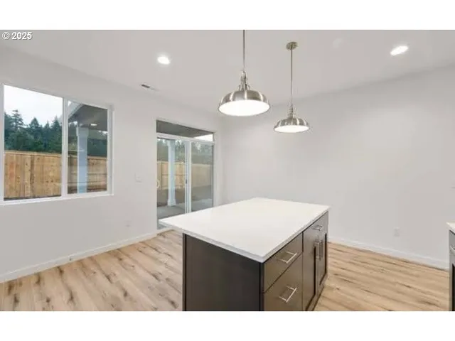 a kitchen with a wooden floor and a chandelier