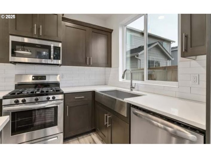 234 West 18th Street Lafayette, OR 97127 - Photo 7 of 27 a kitchen with stainless steel appliances a stove a sink and a microwave