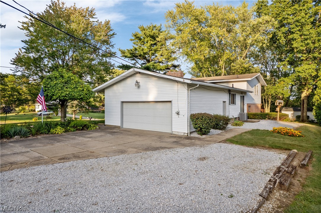 120 Lester Road New Franklin, OH 44319 - Photo 24 of 24 View of front of house with garage, central AC, and a front lawn