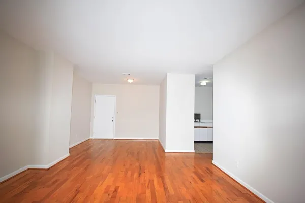 a view of empty room with wooden floor