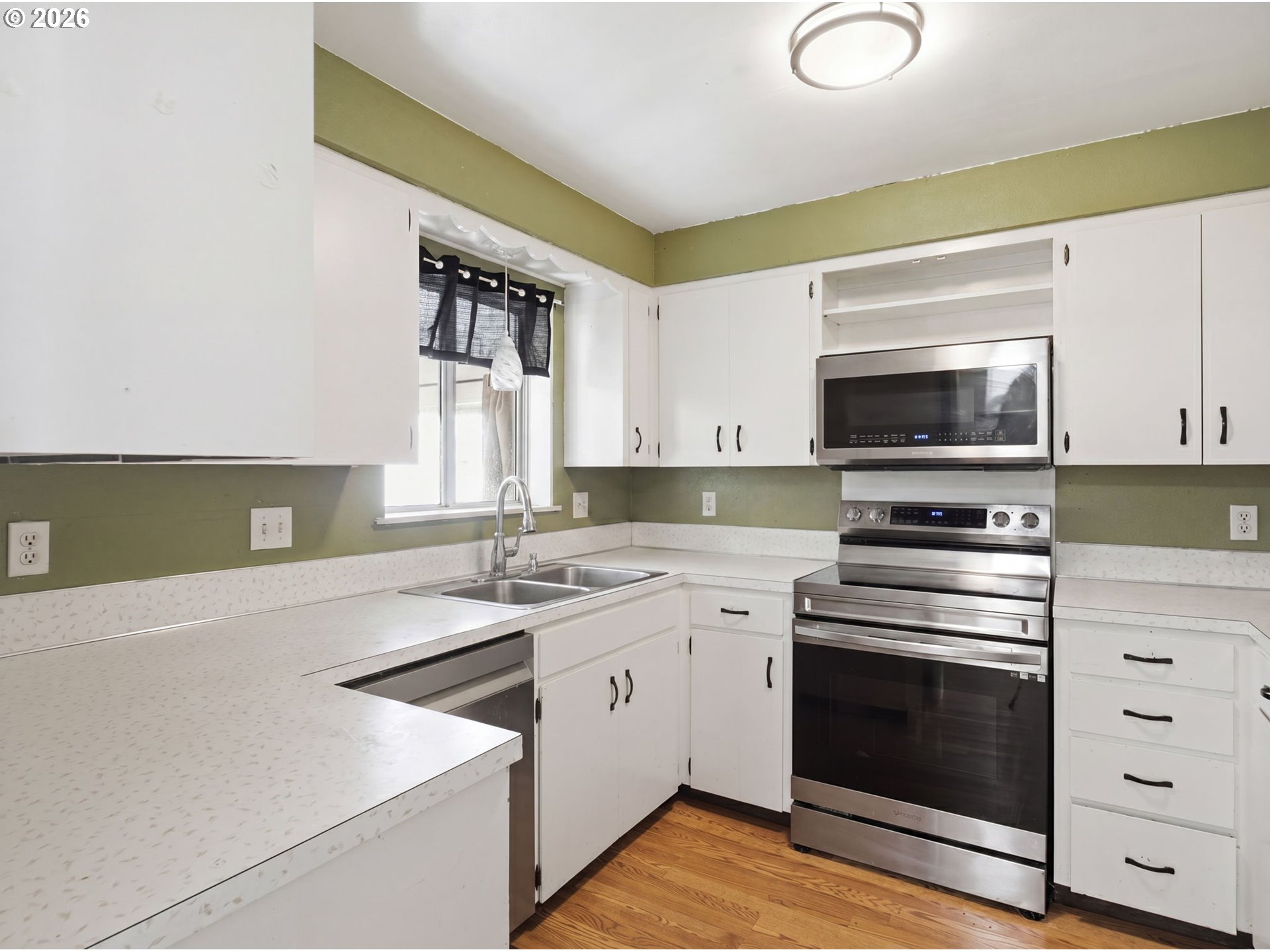 1357 Grove Street Lebanon, OR 97355 - Photo 7 of 37 a kitchen with stainless steel appliances a stove microwave and sink