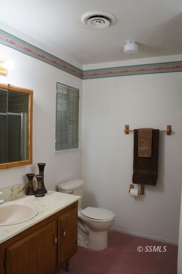 325 Traci Lane Ridgecrest, CA 93555 - Photo 12 of 13 a bathroom with a toilet sink and mirror