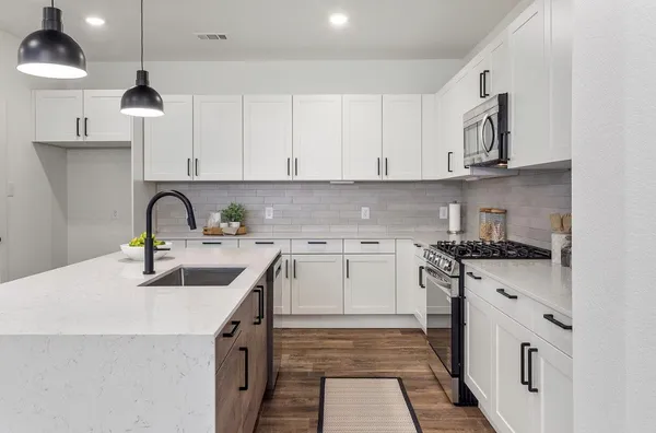 a kitchen with stainless steel appliances granite countertop a sink a stove and cabinets