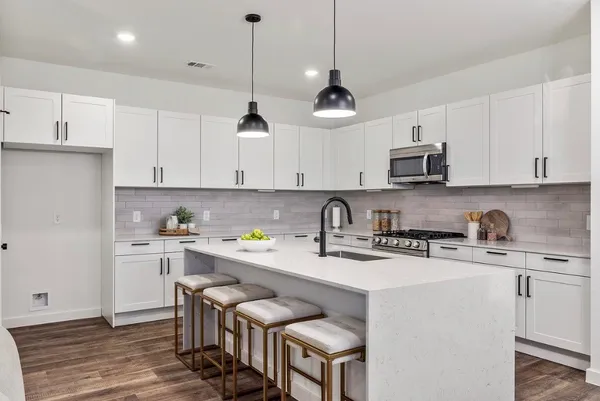 a kitchen with a sink a stove and cabinets