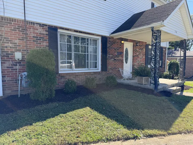 a view of a porch with a table and chairs under an umbrella