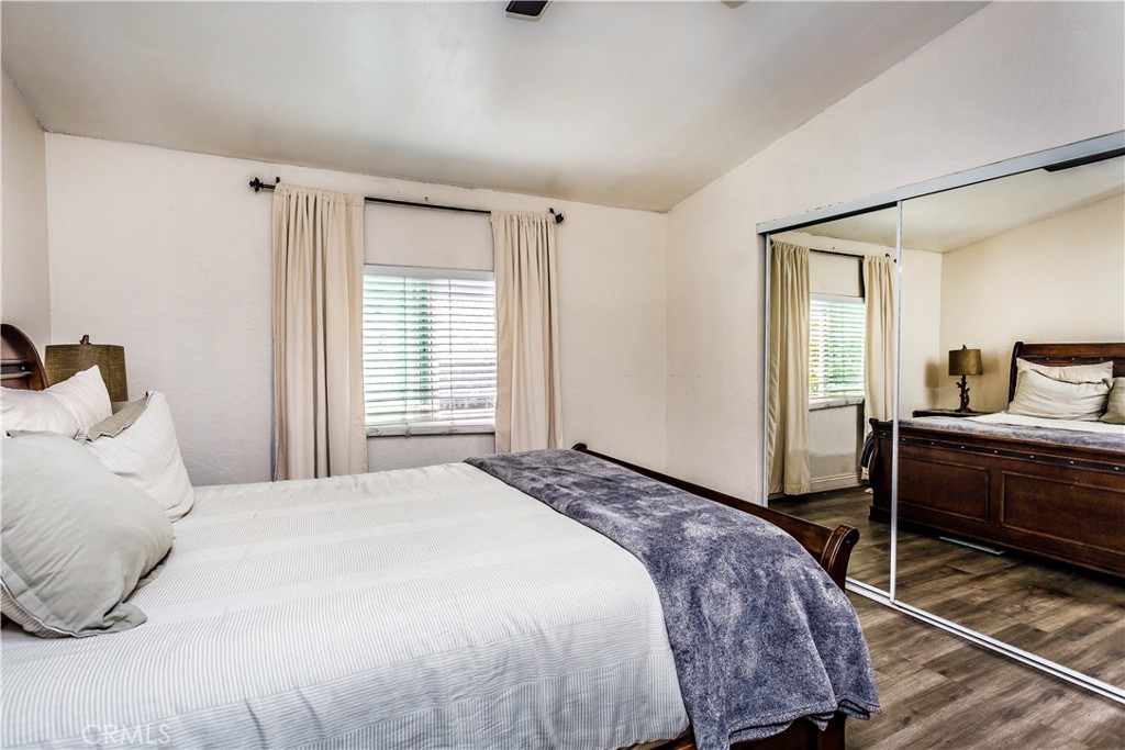 3050 West Ball Road, Unit 200 Anaheim, CA 92804 - Photo 10 of 21 a bedroom with a bed and wooden floor