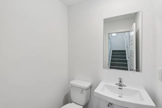 a bathroom with a sink a toilet and mirror