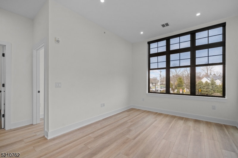 1 Union Avenue, Unit 207 Cresskill, NJ 07626 - Photo 26 of 49 an empty room with wooden floor and windows