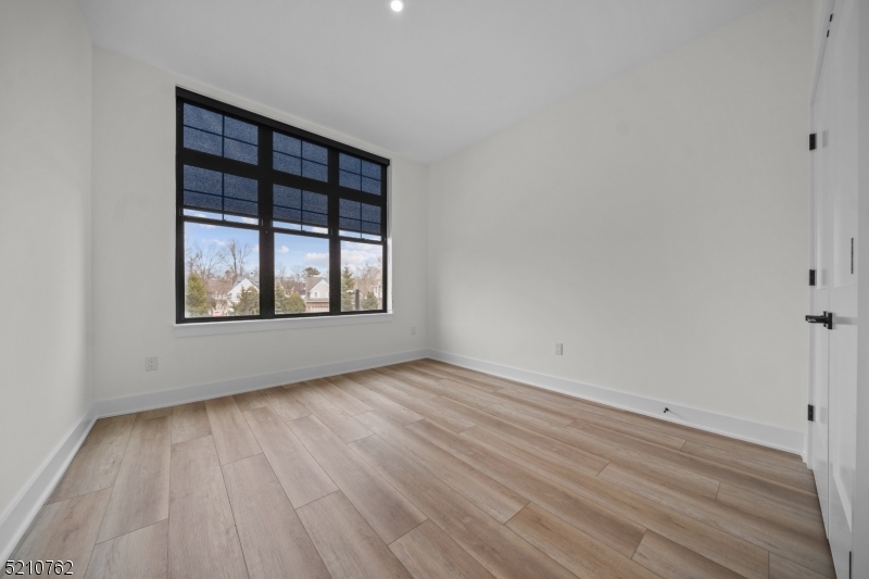 1 Union Avenue, Unit 207 Cresskill, NJ 07626 - Photo 30 of 49 an empty room with wooden floor and windows