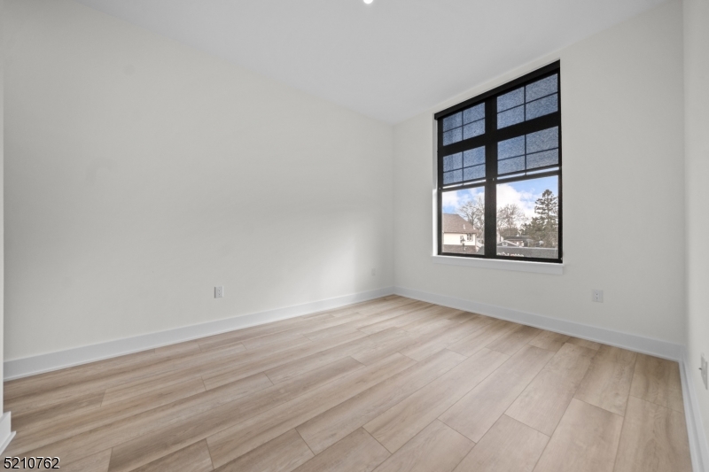 1 Union Avenue, Unit 207 Cresskill, NJ 07626 - Photo 34 of 49 an empty room with wooden floor and windows