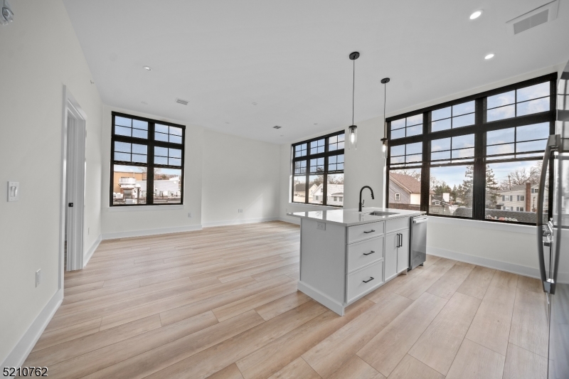 1 Union Avenue, Unit 207 Cresskill, NJ 07626 - Photo 9 of 49 a large white kitchen with granite countertop a large window and white appliances