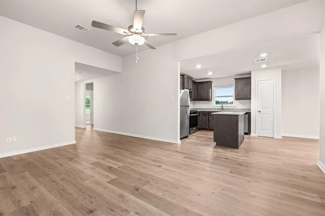 a view of kitchen with granite countertop cabinets and refrigerator