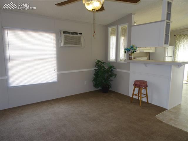 3405 Sinton Road, Unit 233 Colorado Springs, CO 80907 - Photo 7 of 22 Other end of the living room, looking into the kitchen; wall unit A/C