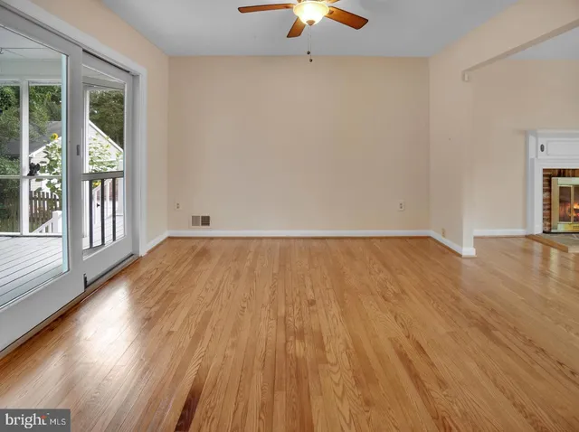 a view of a room with wooden floor fan and a window