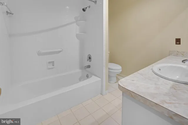 a bathroom with a granite countertop sink a toilet and bathtub