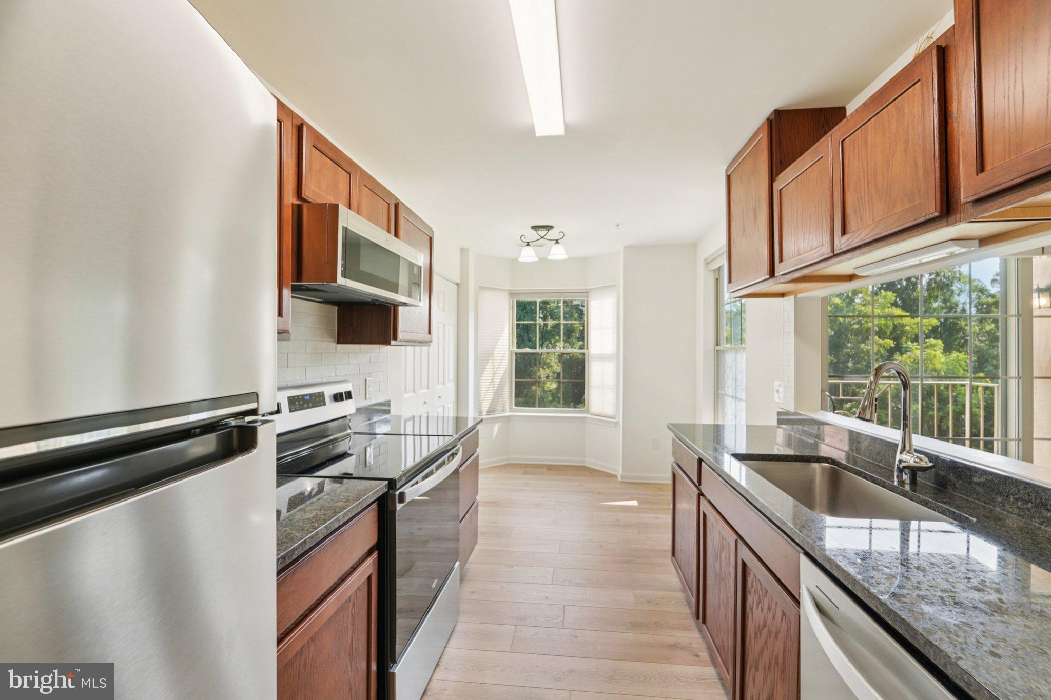 3500 Thomas Pointe Court, Unit 2B Abingdon, MD 21009 - Photo 12 of 37 a kitchen with stainless steel appliances granite countertop a sink stove and microwave