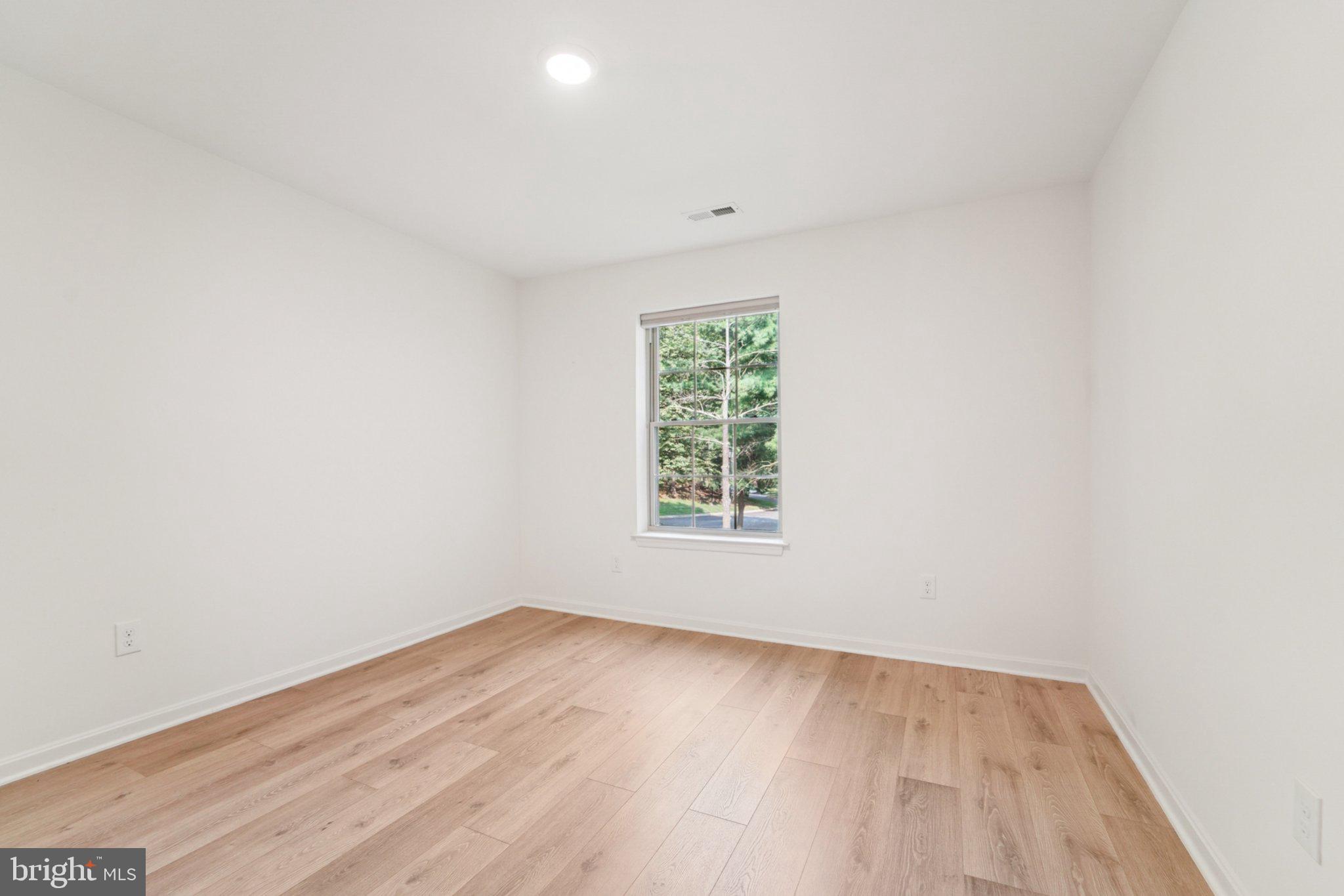 3500 Thomas Pointe Court, Unit 2B Abingdon, MD 21009 - Photo 22 of 37 an empty room with wooden floor and windows