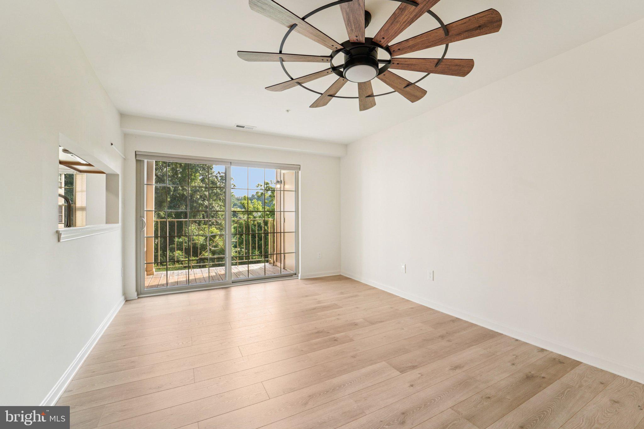3500 Thomas Pointe Court, Unit 2B Abingdon, MD 21009 - Photo 6 of 37 an empty room with wooden floor fan and windows