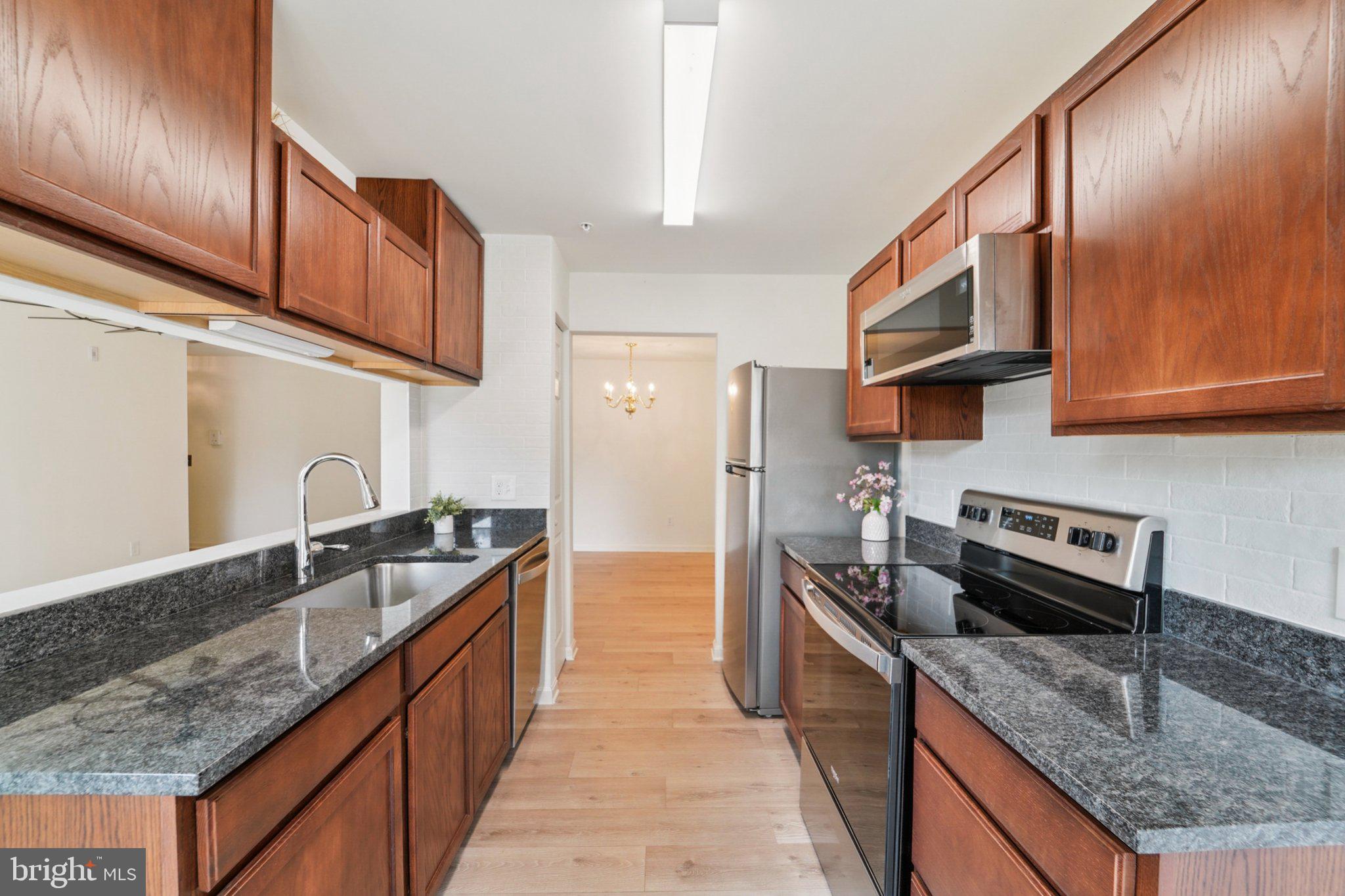 3500 Thomas Pointe Court, Unit 2B Abingdon, MD 21009 - Photo 10 of 37 a kitchen with stainless steel appliances granite countertop a sink stove and refrigerator