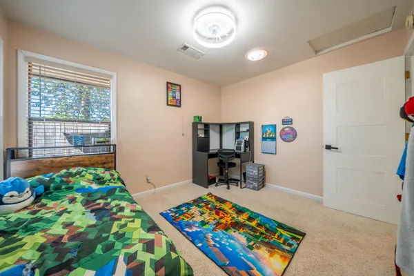 a bed room with a bed window and a chair in it