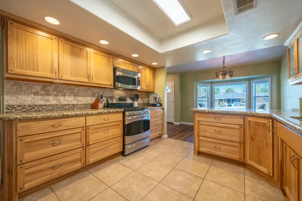 a kitchen with stainless steel appliances granite countertop a refrigerator stove and oven
