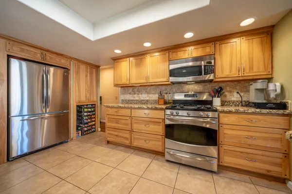 a large kitchen with stainless steel appliances a refrigerator and a sink