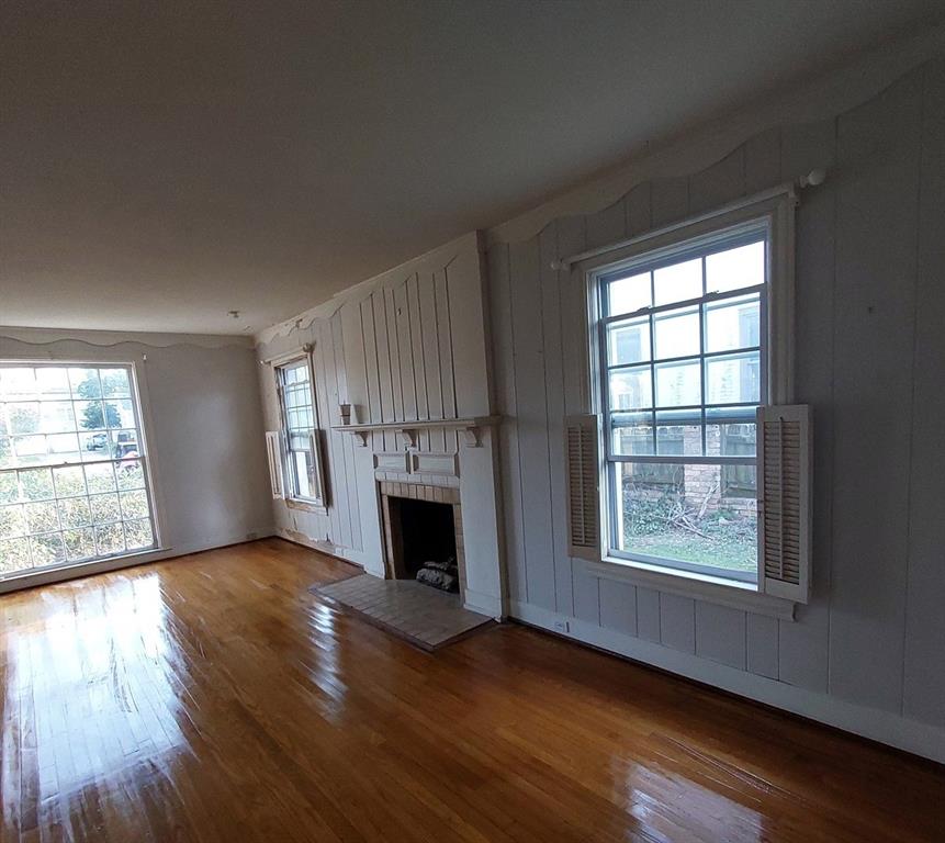 325 West 4th Street Tyler, TX 75701 - Photo 25 of 40 an empty room with wooden floor fireplace and windows