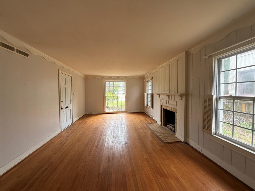 325 West 4th Street Tyler, TX 75701 - Photo 4 of 40 a view of empty room with a fireplace and wooden floor