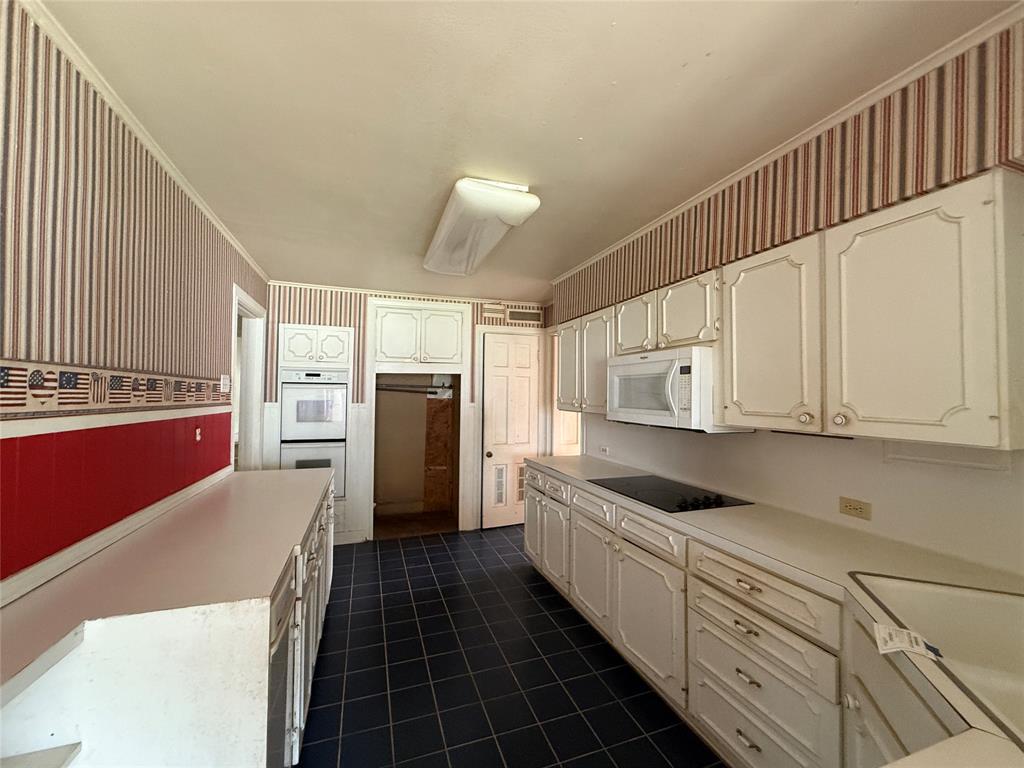 325 West 4th Street Tyler, TX 75701 - Photo 9 of 40 a kitchen with granite countertop a refrigerator and a stove top oven