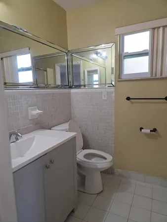 a bathroom with a sink toilet and window