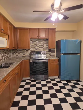 a kitchen with a checkered floor and white cabinets