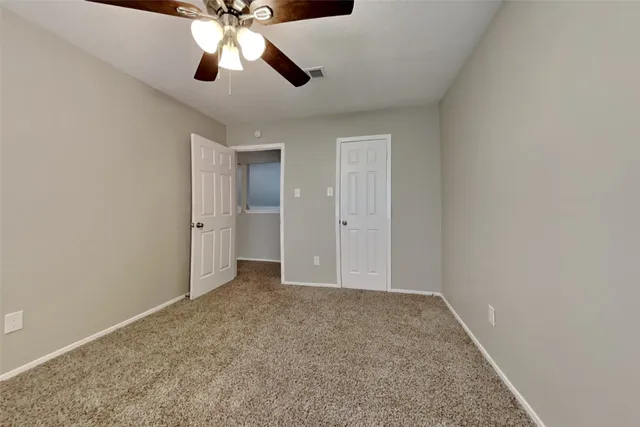 an empty room with closet and chandelier fan